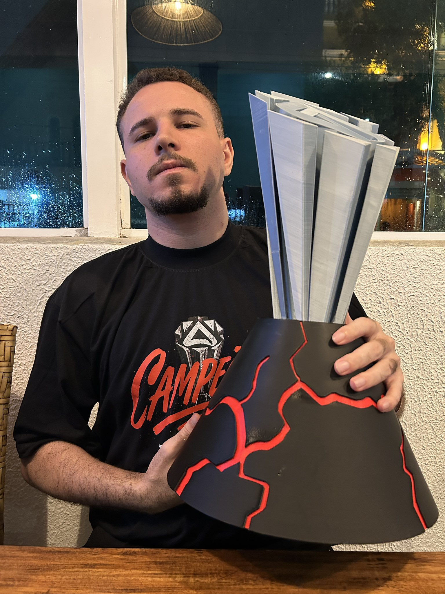 Coach Apolo segurando o troféu de campeão de um campeonato mineiro de League of Legends